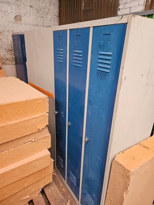 un casier bleu à côté d'un tas de bois