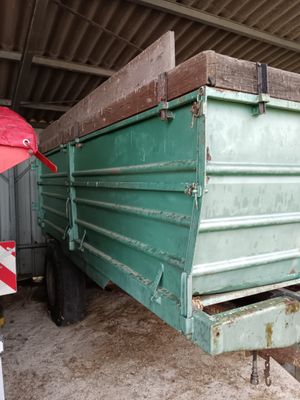 une photo d'un camion-benne vert garé dans un garage