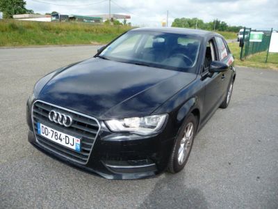 La voiture noire est garée sur le bord de la route, dans le parking.