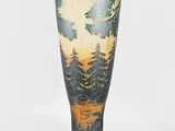 a vase that is sitting on a stand on a white surface