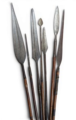 a set of five old knives with wooden handles on a white surface