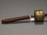 a small brass bell with a wooden handle on a table