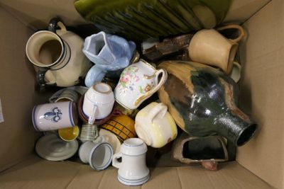 une boîte en carton remplie de nombreux vases de toutes sortes