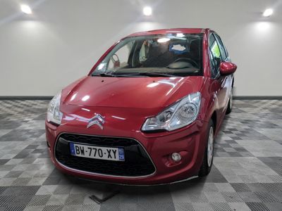 une voiture rouge garée sur un sol à damier