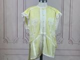 an image of a yellow shirt on a mannequin stand in front of a wall