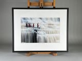 photo encadrée représentant une cascade sur laquelle se tiennent trois personnes