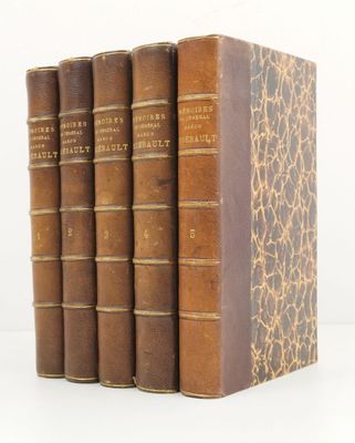 three old books sitting on top of each other on a white surface
