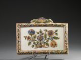 une boîte richement décorée de fleurs et de feuilles, posée sur un socle