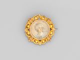 une broche plaquée or représentant le portrait d'une femme