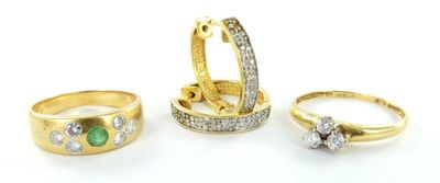 trois bagues en or serties de diamants et d'émeraudes sur fond blanc