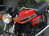 a red and black motorcycle parked in front of a house