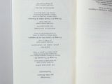 an open book with a poem in it on a table