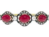 un gros plan d'une bague ornée de deux pierres rouges