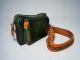 a green and orange bag and a brown strap