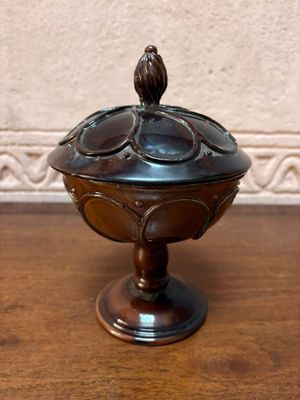 un petit bol en métal posé sur une table en bois