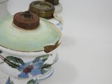 a close up of a vase with a lid on a table