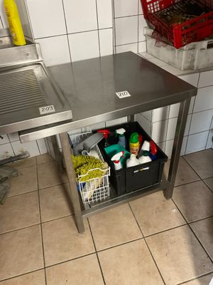 a stainless steel work table in a kitchen with a sink