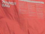 the back of a red jacket with a white and black logo on it