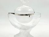 un saladier en verre transparent muni d'un couvercle en argent orné d'un oiseau