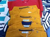 many sweaters laid out on a bed with tags on them
