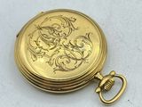 an image of a gold pocket watch sitting on a white surface