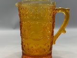 an image of a yellow glass pitcher sitting on top of a table