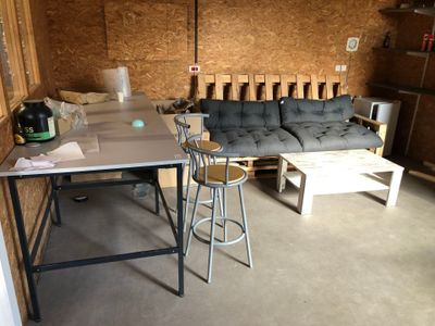 Table d'atelier rectangulaire, canapé artisanal sur palettes… - Photo 1
