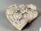 a piece of rock with green crystals on top of it
