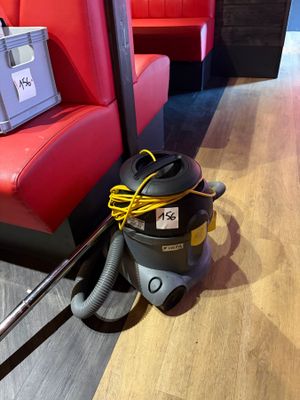 a vacuum that is sitting on the floor next to a couch