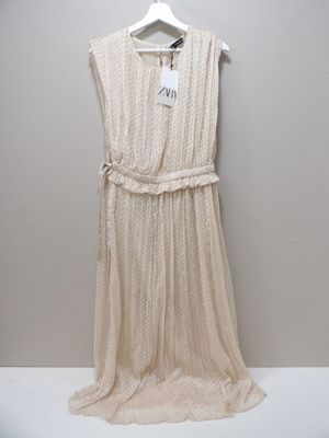 a white dress hanging on a hanger on a wall