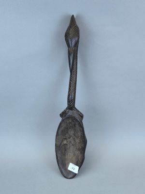une cuillère ornée d'un oiseau, posée sur une table