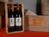 three bottles of wine in a wooden box on a table