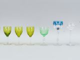 several different colored wine glasses are lined up in a row