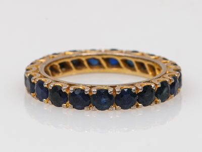 un gros plan d'une bague en or sertie de saphirs bleus