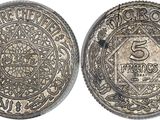 a silver coin with the number 5 on it