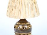 une petite lampe surmontée d'un abat-jour en paille