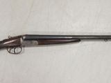 un fusil de chasse avec une crosse et un canon en bois