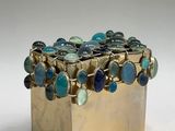 a gold box with a bunch of blue stones in it