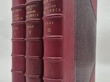 trois livres rouges superposés sur une surface blanche