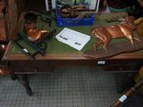 a wooden table with a metal deer on it