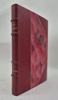 un vieux livre à la couverture rouge posé sur une surface blanche