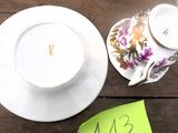 une tasse et une soucoupe posées sur une table, sur laquelle se trouve un mot