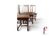 four wooden chairs sitting next to each other on a white surface