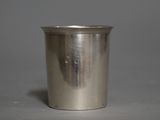 une coupe ancienne en argent avec une anse, sur fond gris