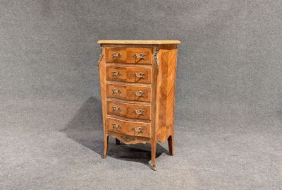 an image of a small wooden chest of drawers against a gray background
