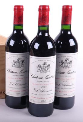 trois bouteilles de vin rouge posées à côté d'une caisse en bois