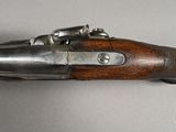 a close up of a gun with a wooden handle on a table