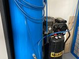 un compresseur d'air bleu posé à côté d'un réservoir bleu