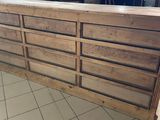 a large wooden counter with many drawers on it