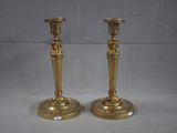pair of antique brass candlesticks on a white background